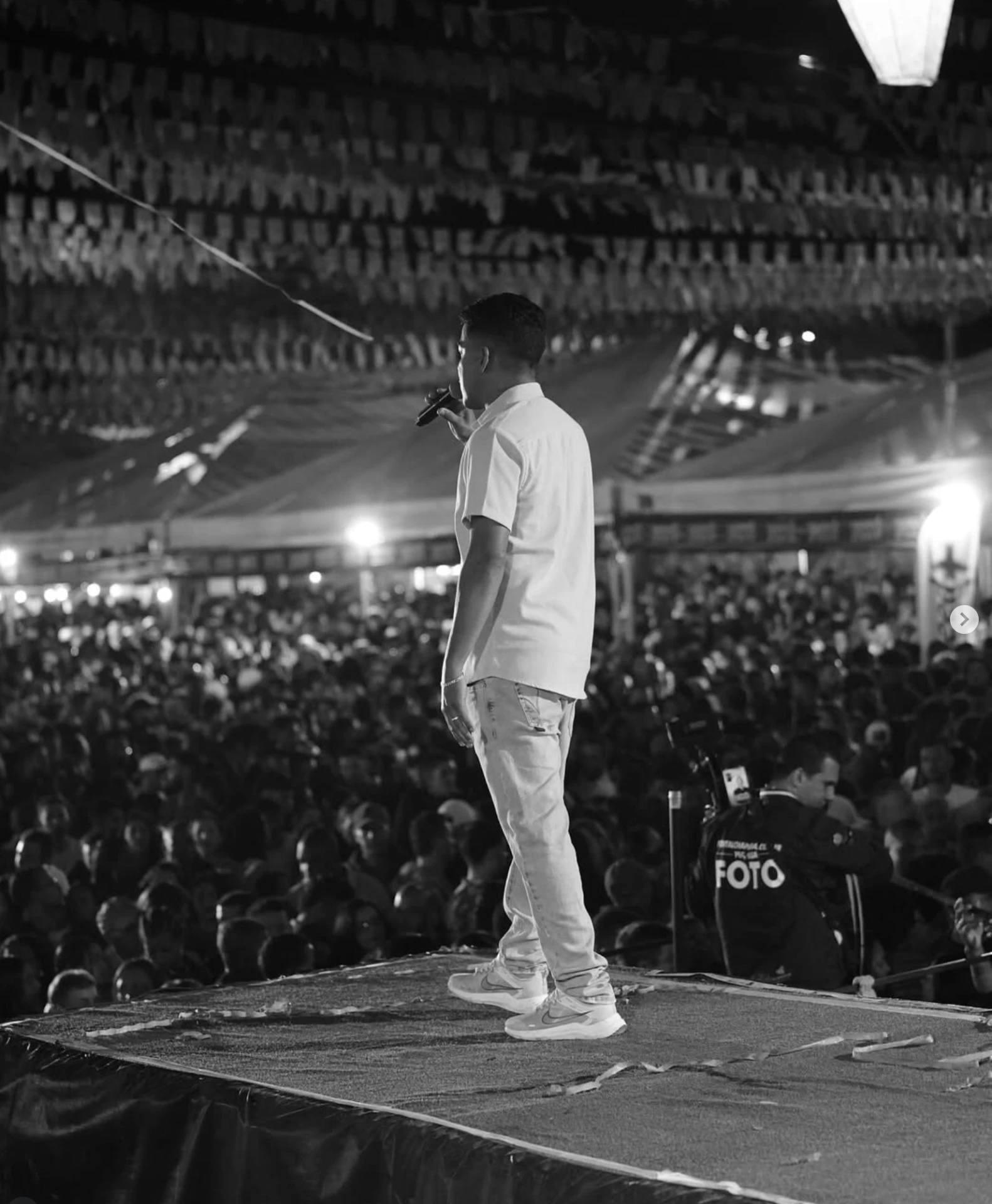 Nilson Santos diante do público durante evento, fotografia em preto e branco